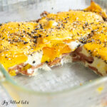 taylor ham egg and cheese casserole in a glass baking dish topped with everything bagel seasoning