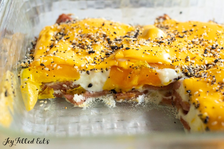 taylor ham egg and cheese casserole in a glass baking dish topped with everything bagel seasoning