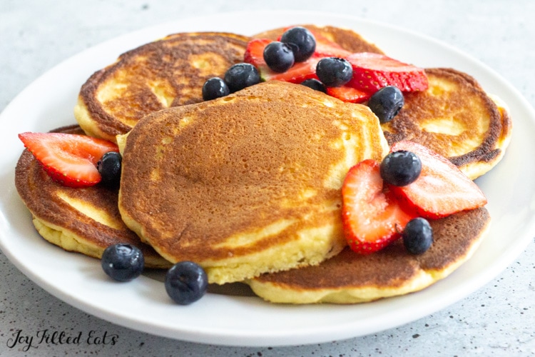 plate with keto buttermilk pancakes topped with berries
