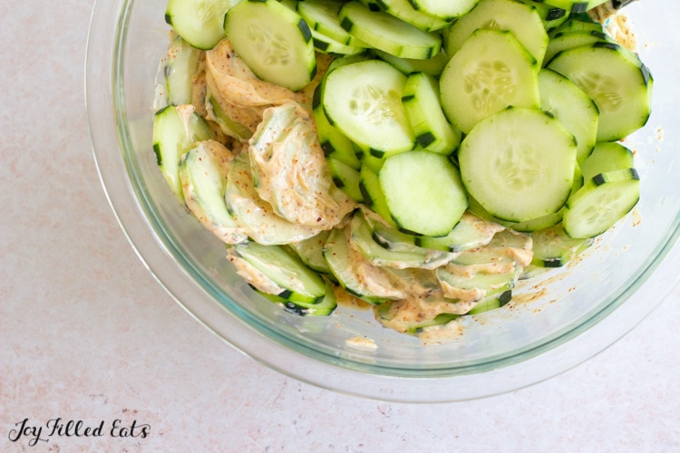 cucumbers in bowl with dressing