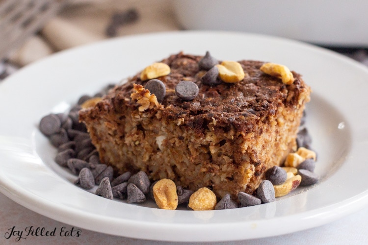baked protein oatmeal on a plate topped with chocolate sauce and peanuts