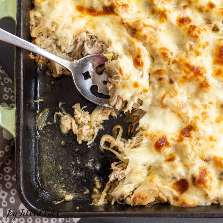 keto philly cheesesteak chicken casserole in a cast iron pan with a spoon