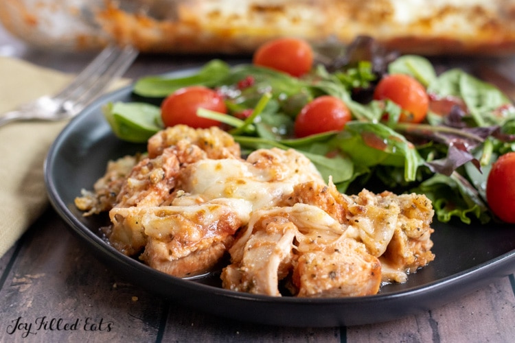 serving of keto chicken parmesan casserole on a plate with salad