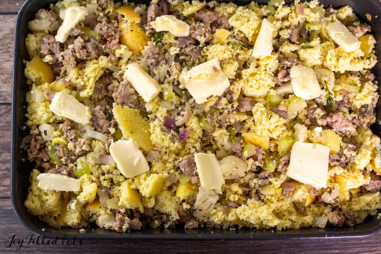 keto stuffing in baking dish topped with pats of butter