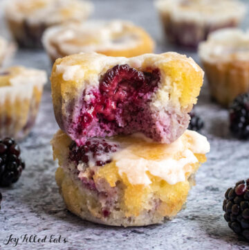 close up of two almond flour blackberry muffins stacked on top of each other