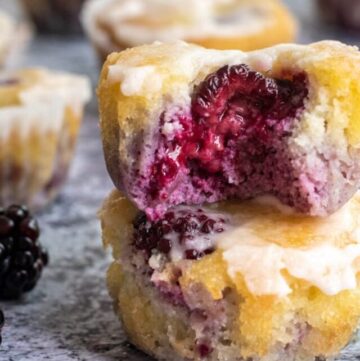 close up of two almond flour blackberry muffins stacked on top of each other