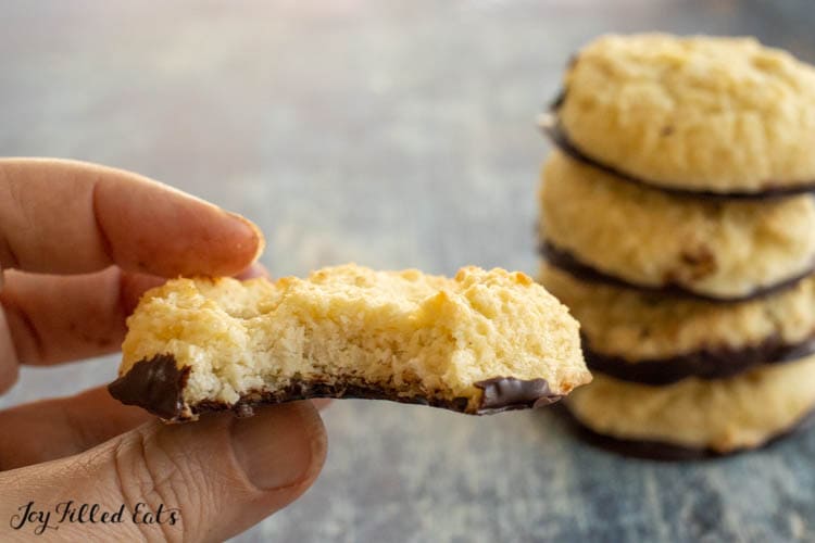 hand holding keto coconut cookie missing a bite