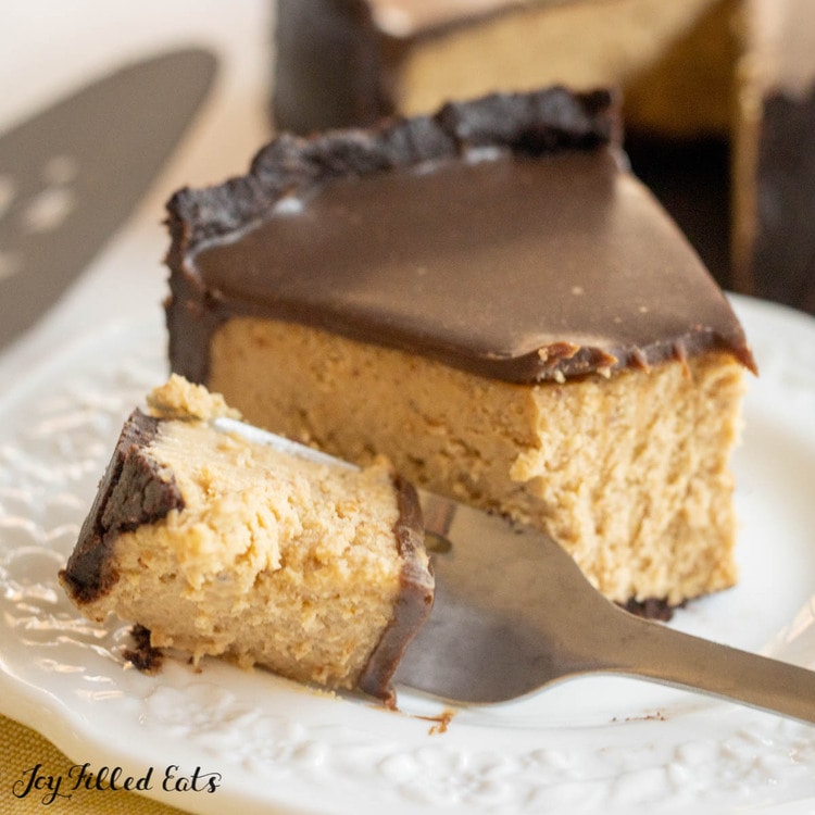 close up of keto peanut butter cheesecake on a plate with bite on a fork