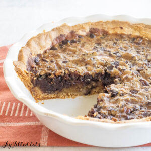low carb chocolate pecan pie with a slice missing from the pie pan