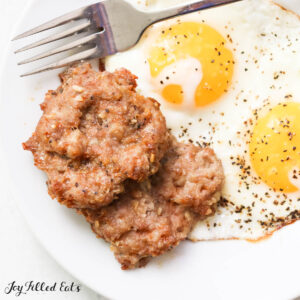 two air fryer sausage patties on a plate with eggs