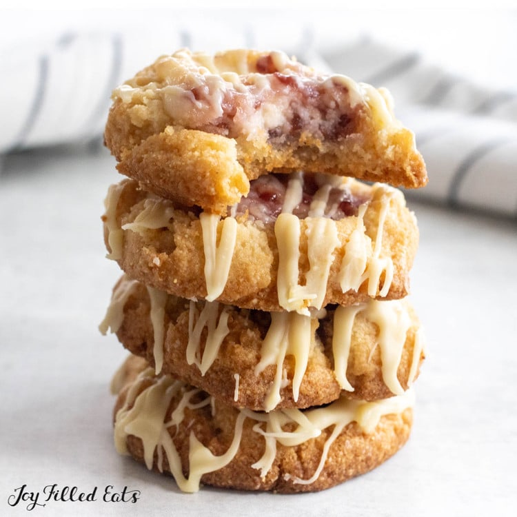 stack of raspberry cheesecake cookies with top cooking missing a bite