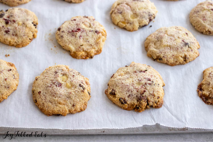 white chocolate and raspberry cookies on a parchment lined cookie sheet close up