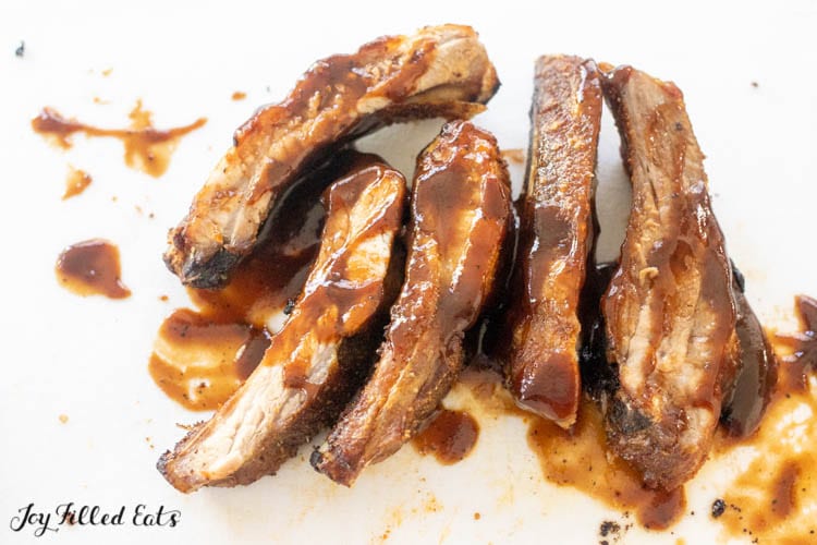 air fryer baby back ribs with sauce on cutting board