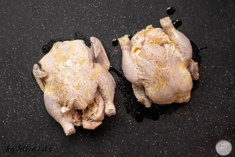 two raw cornish hens on cutting board