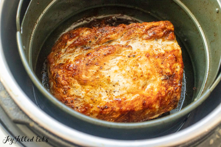 air fryer with pork roast in basket