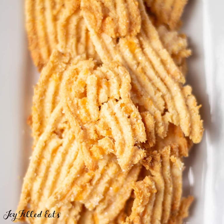 pile of keto cheese straws on white plate