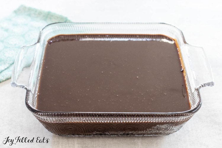 glass pan with cake topped with ganache