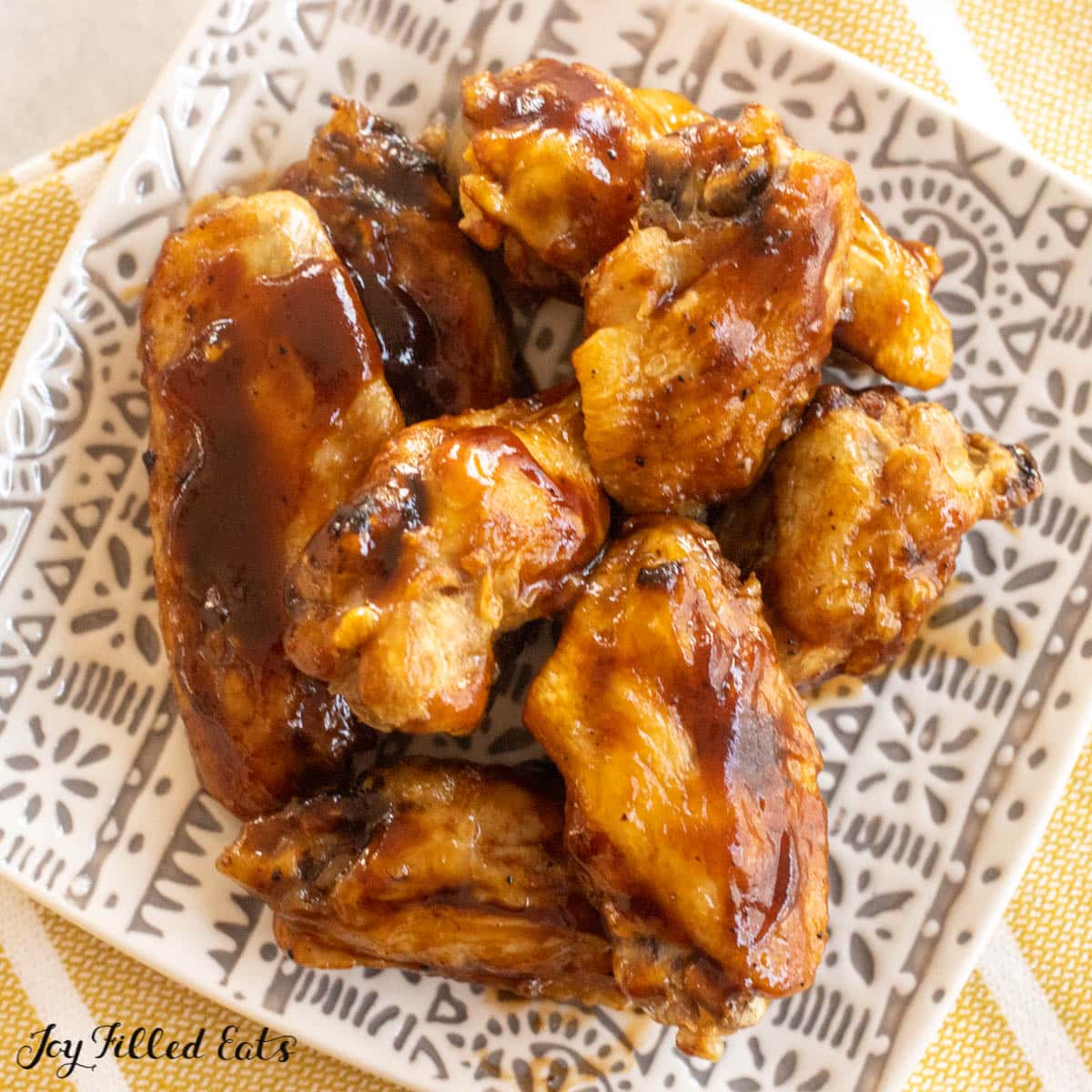 air fryer frozen chicken wings recipe cooked and served in bbq sauce on small plate