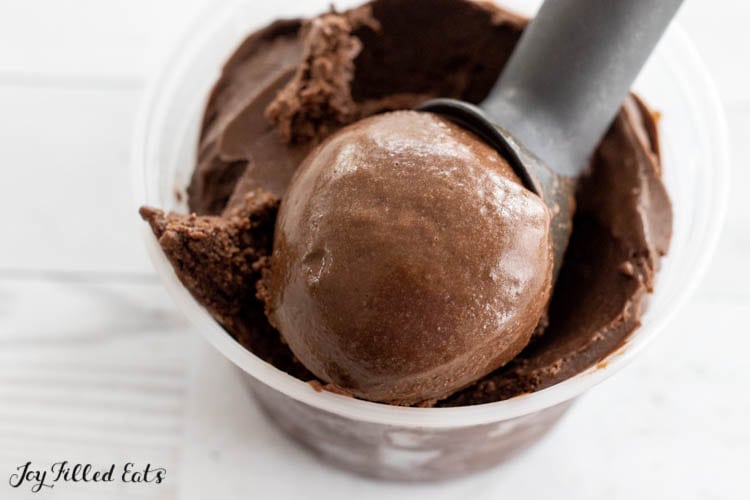 ice cream scoop in a container of chocolate avocado ice cream