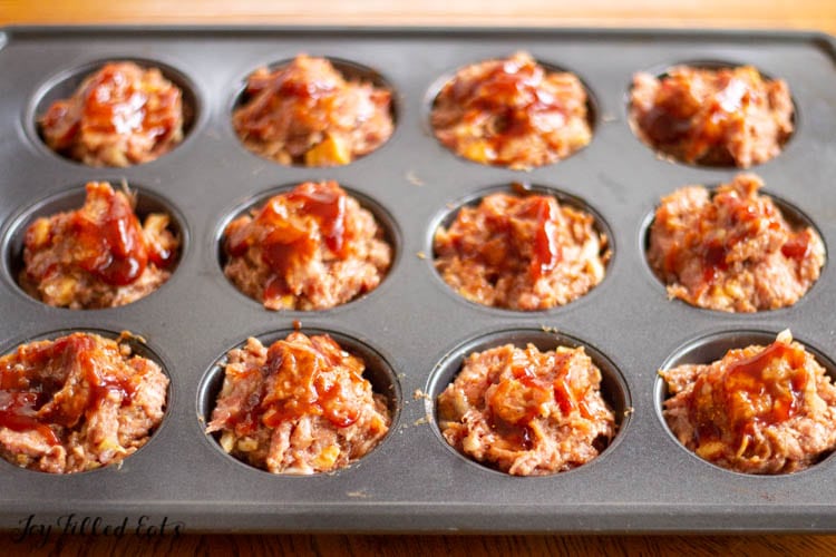 muffin tin with raw meat mixture
