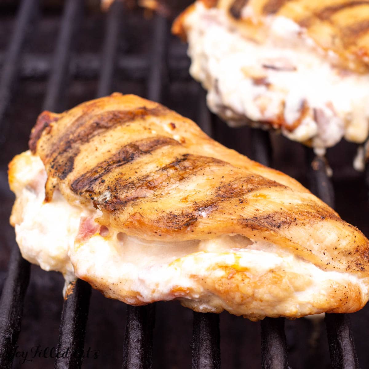 close up of stuffed chicken breasts on grill