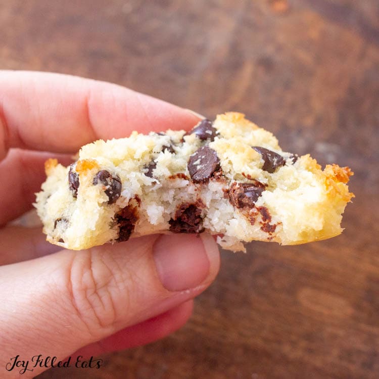 hand holding keto chocolate chip coconut macaroon with large bite missing