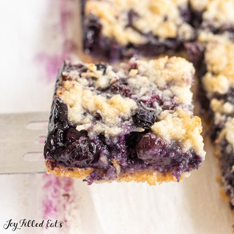 one of the keto blueberry pie bars being lifted on a spatula