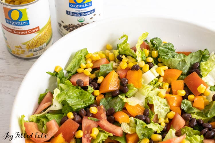 black beans and corn on salad with cans behind