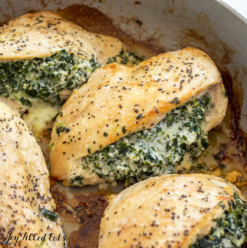 close up of spinach and ricotta stuffed chicken in a skillet