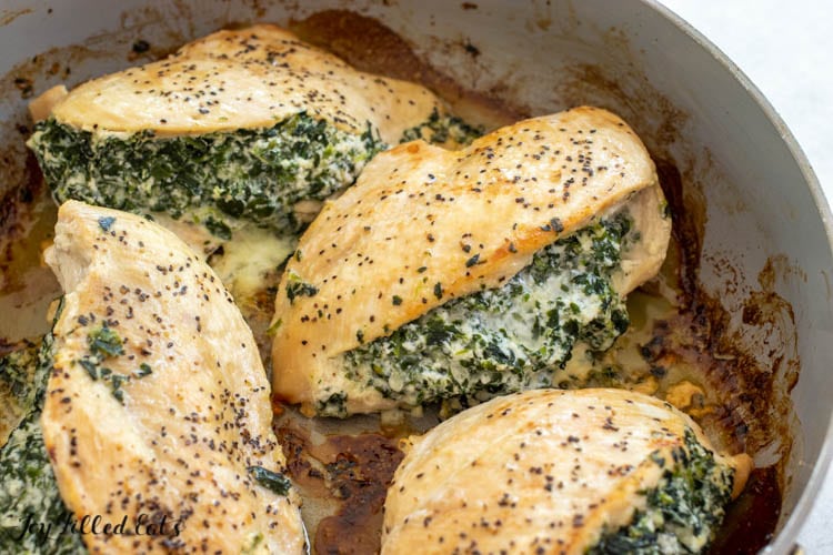 close up of spinach and ricotta stuffed chicken in a skillet