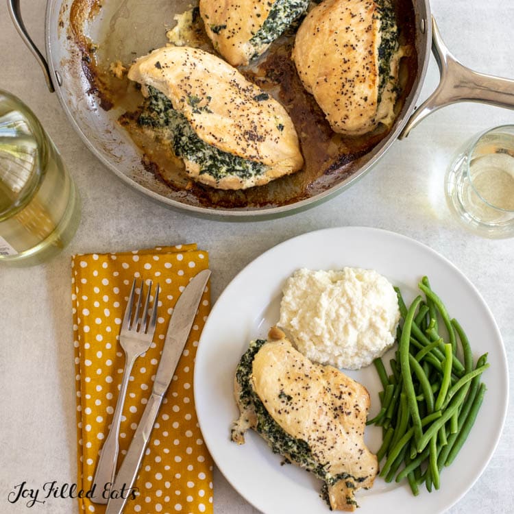 overhead shot of spinach and ricotta stuffed chicken in skillet and on a plate