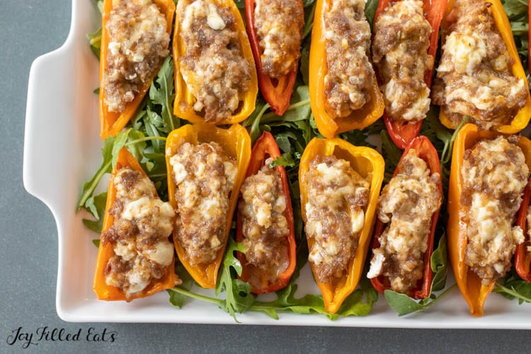 platter with Stuffed Peppers with Cream Cheese and Sausage on a bed of arugula