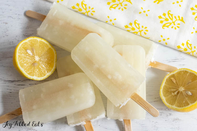 keto lemonade popsicles in a pile on a white surface
