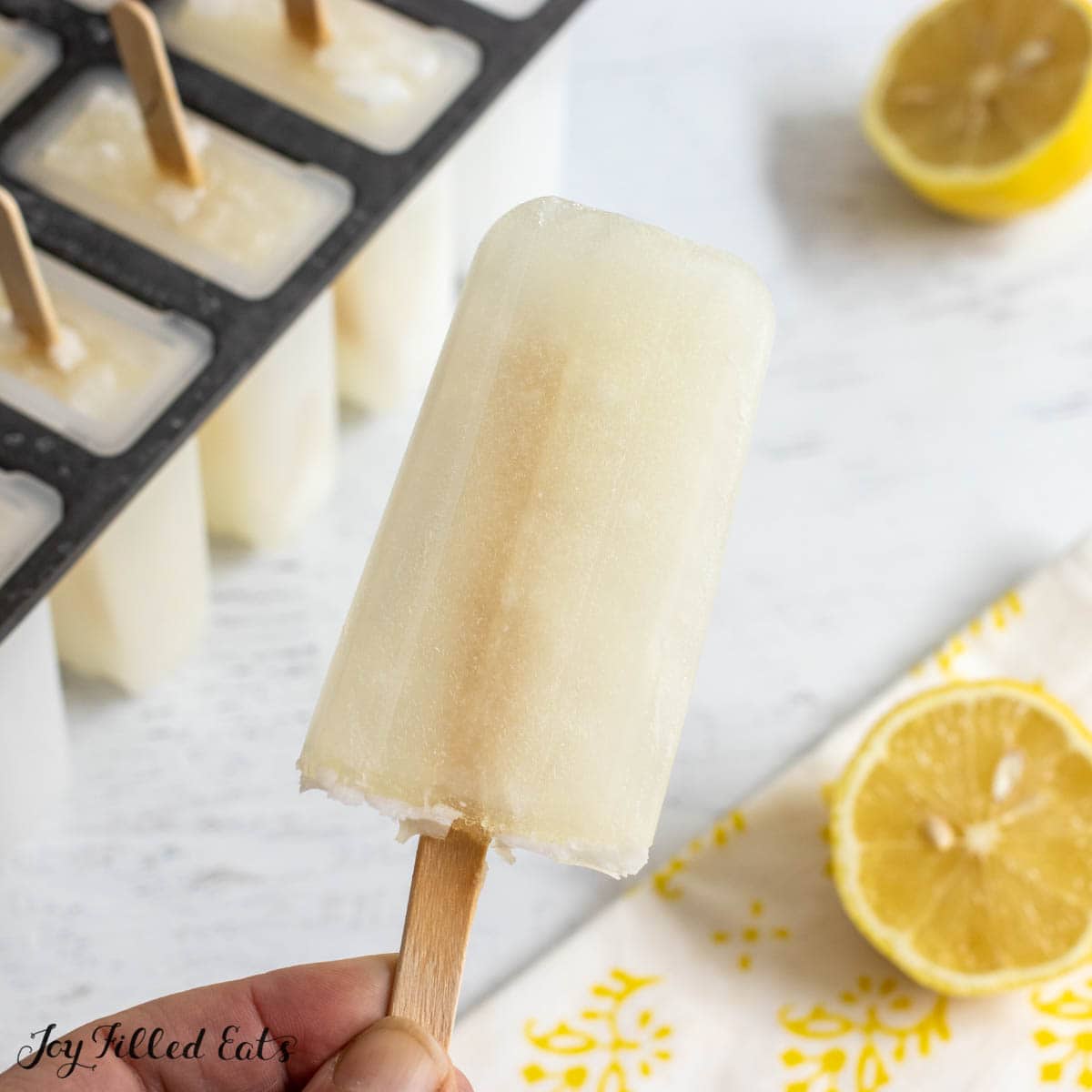 hand holding a low carb lemon popsicle