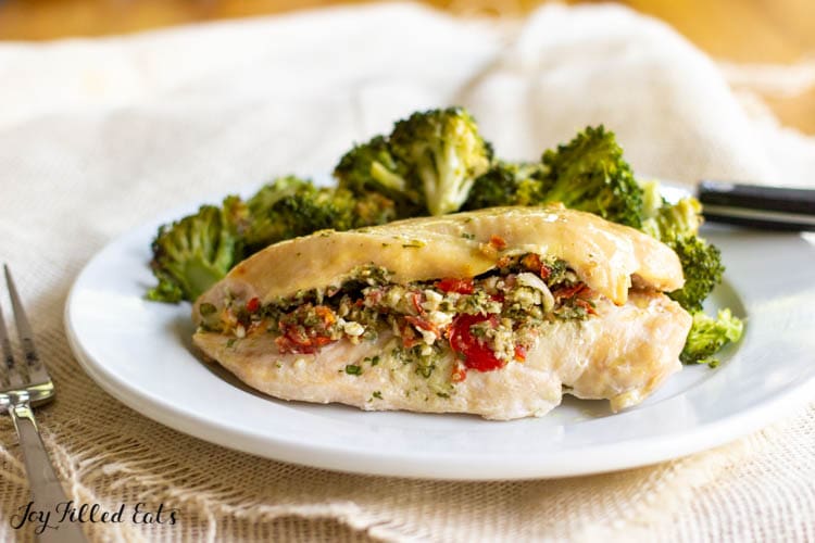 stuffed greek chicken breast on a plate with broccoli