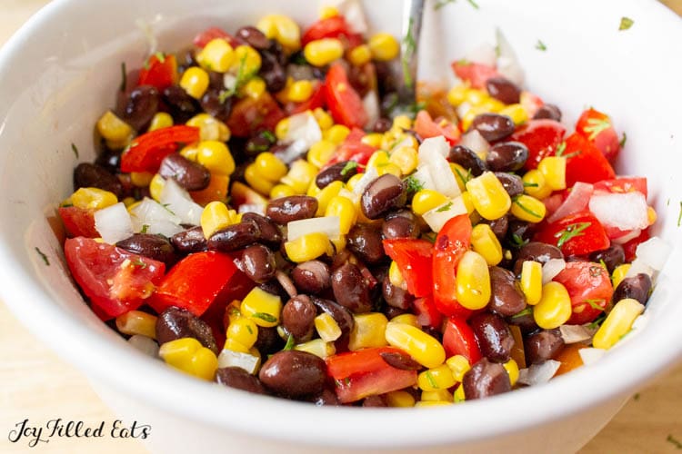 bowl with black beans corn tomatoes onions and cilantro
