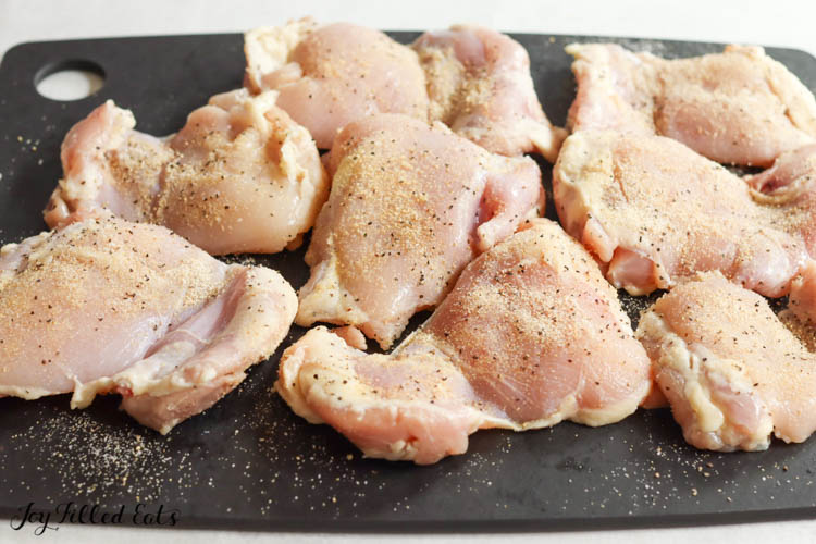 raw chicken on cutting board with dry seasonings