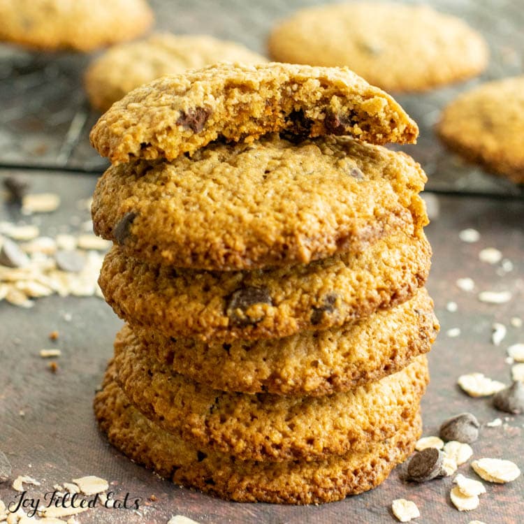 one of the oat flour chocolate chip cookies with a bite missing on top of a stack