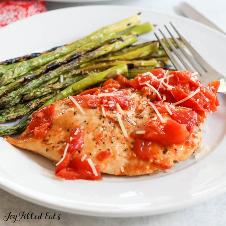 dinner plate with pomodoro chicken breast and grilled asparagus