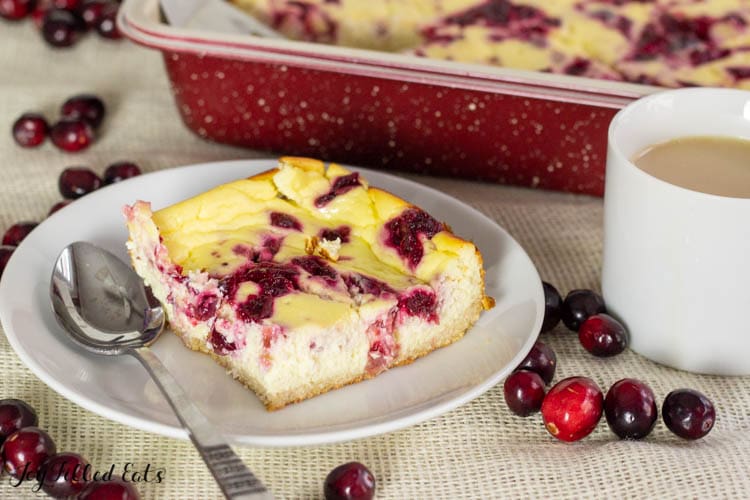 one of the cheesecake bars with cranberry on a plate