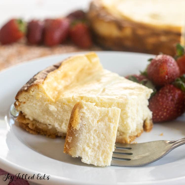 bite of keto cheesecake on a fork next to slice