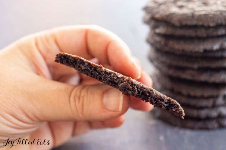 hand holding a halved chocolate almond flour cookie