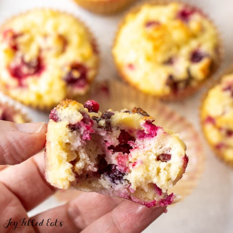 hand holding one of the keto cranberry muffins with a bite missing