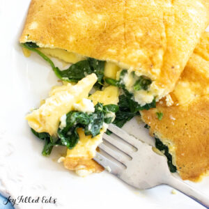 close up of spinach feta omelet on plate with bite on fork
