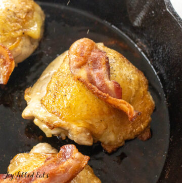close up of cast iron chicken with bacon