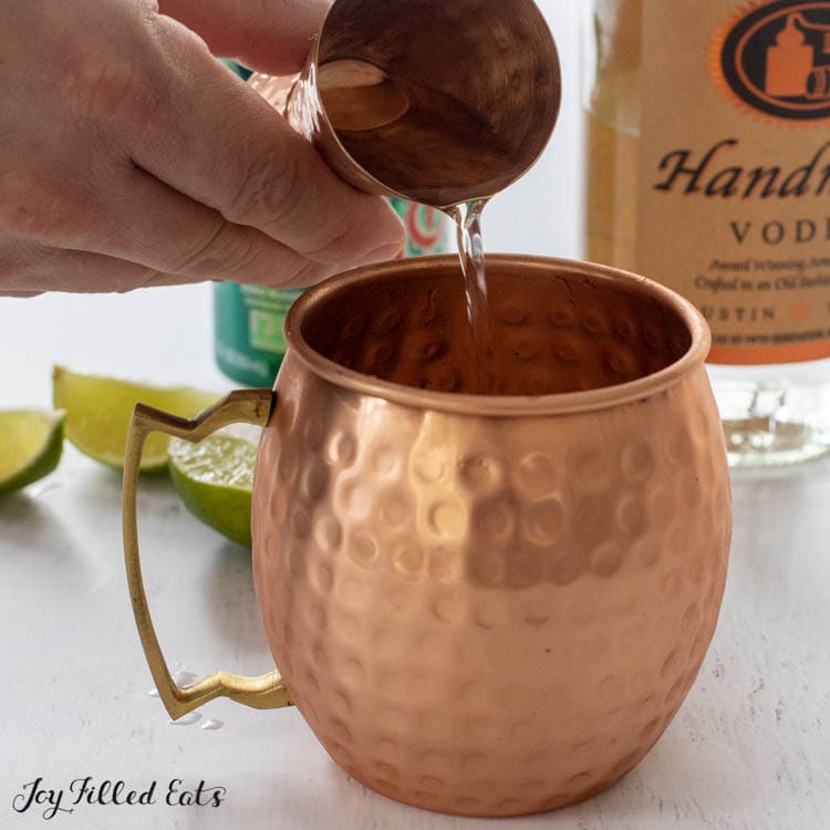 hand pouring liquid into mug