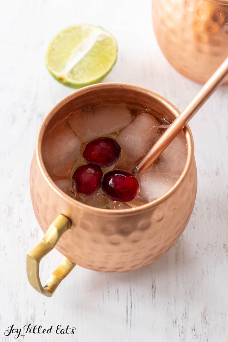 keto moscow mule in copper mug with cranberries straw
