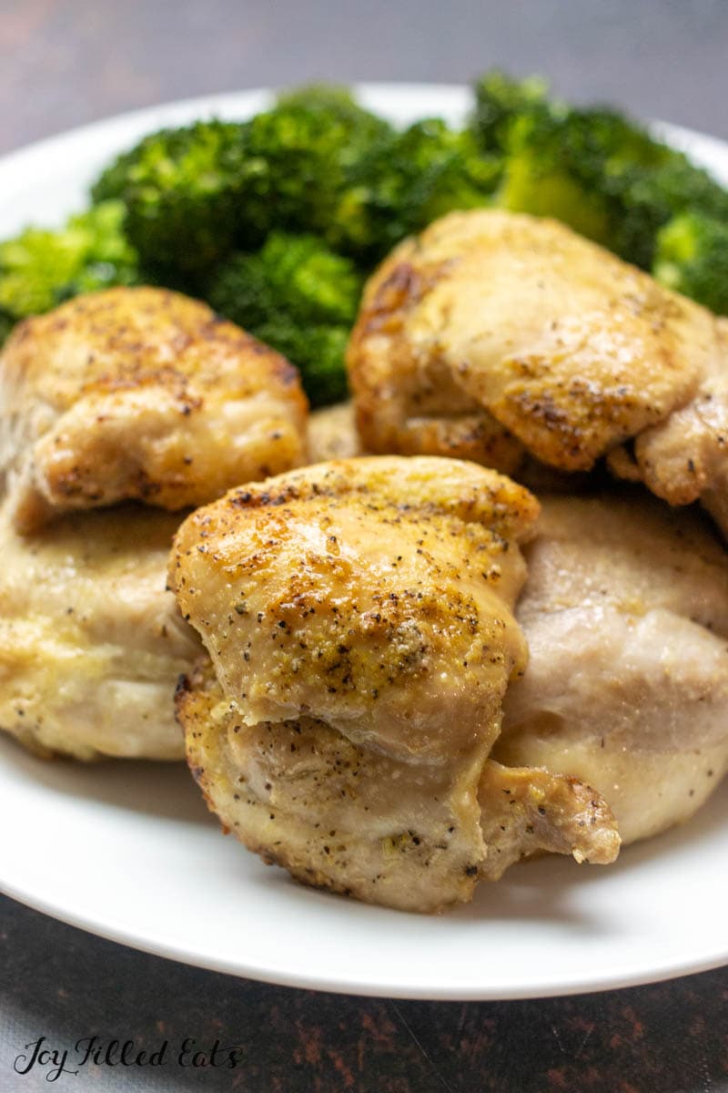 close up of air fryer boneless skinless chicken thighs on a plate with broccoli