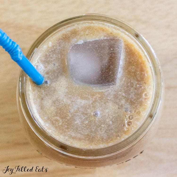 overhead shot of iced coffee with a straw with creamer from the keto coffee creamer recipe