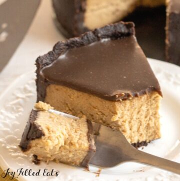 close up of keto peanut butter cheesecake on a plate with bite on a fork